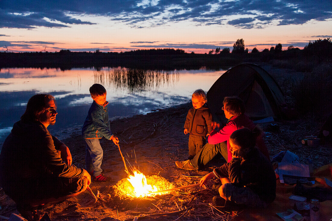 Family at campfire, Werbeliner See, Saxony, Germany