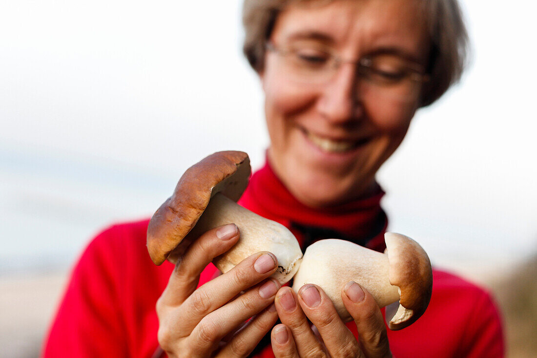 Woman holding two yellow boletuses, Rerik, Mecklenburg-Western Pomerania, Germany