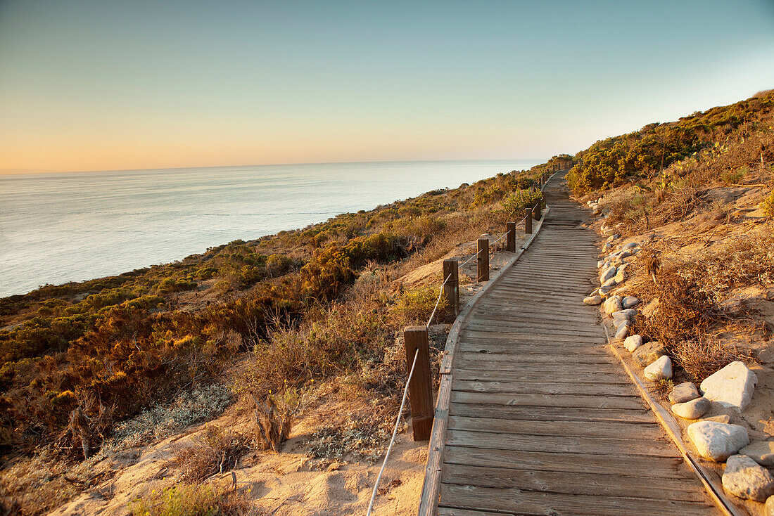 USA, California, Malibu, a boardwalk walking path at Big Dume with the Pacific Ocean in the distance