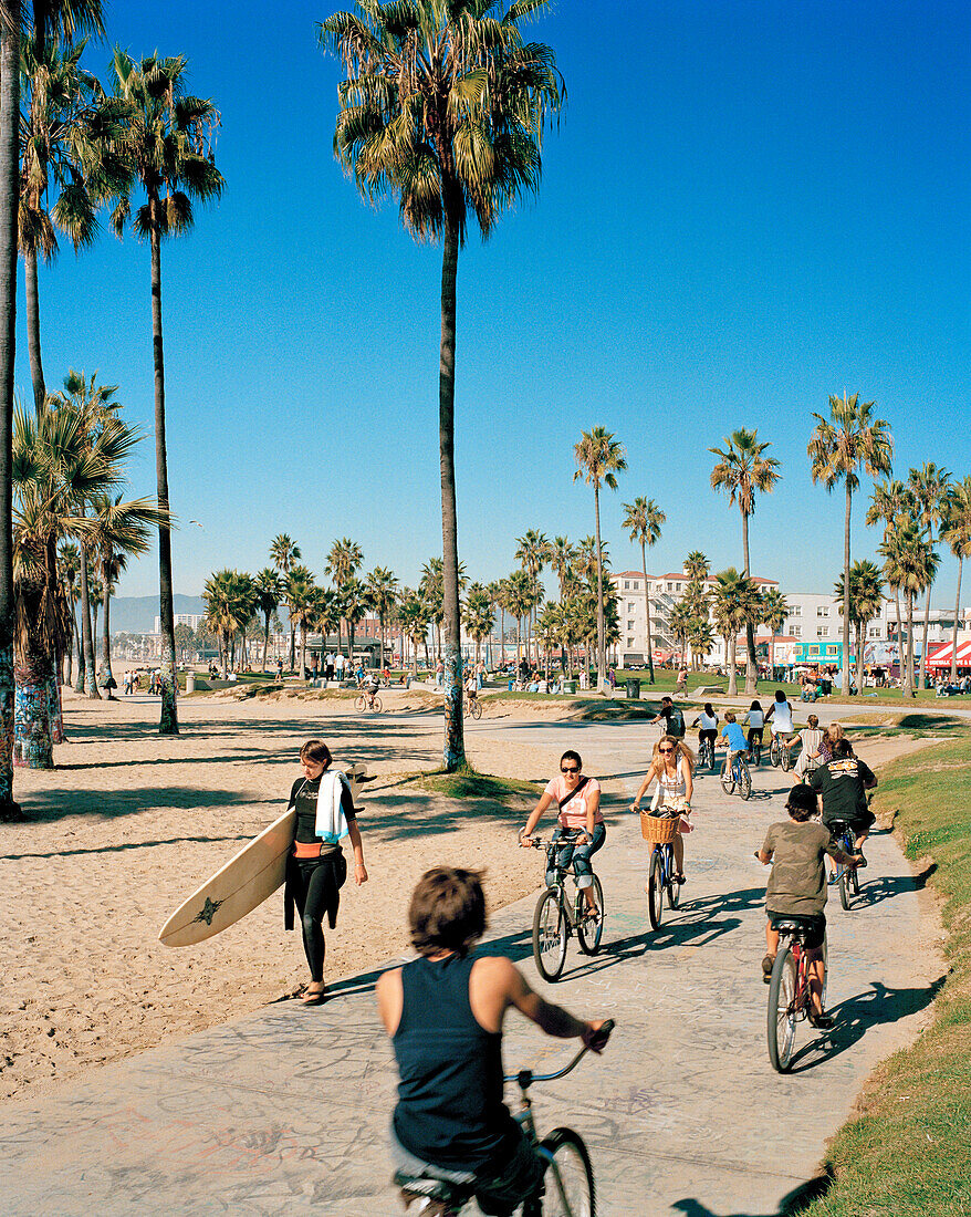 USA, California, Los Angeles, Venice Beach, surfers and bikers on the Venice Beach Boardwalk