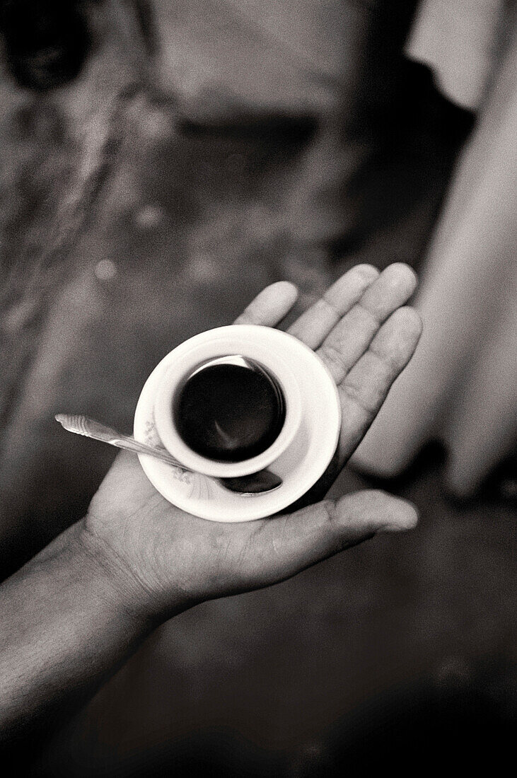 ERITREA, Massawa, a hand holding a small cup of coffee (B&W)