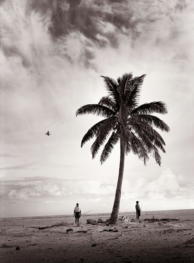 FIJI, Northern Lau Islands, a father and son wander across a small remote island to go fishing (B&W)