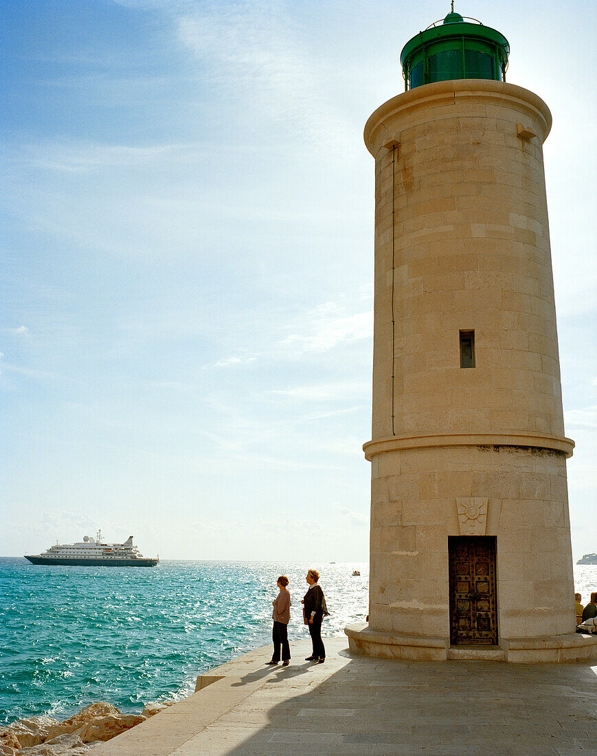 FRANCE, Nice, women by lighthouse next to the Mediterranean Sea