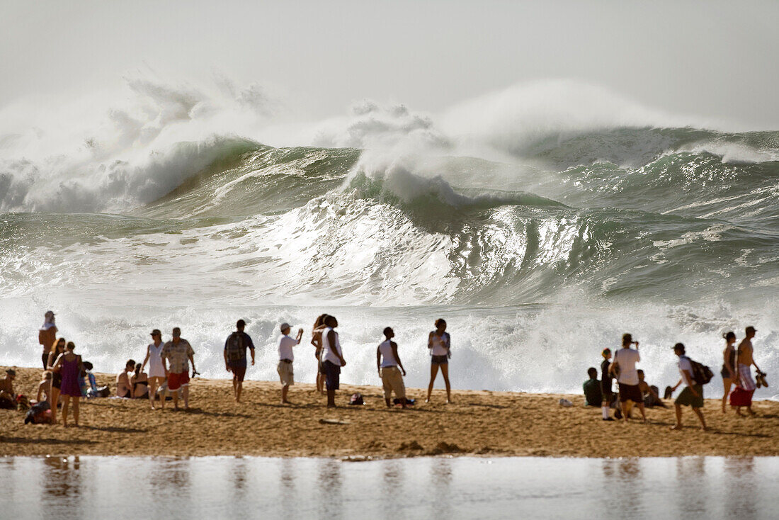 USA, Hawaii, Oahu, the North Shore, people watching enormous shorebreak and distant waves at Waimea Bay