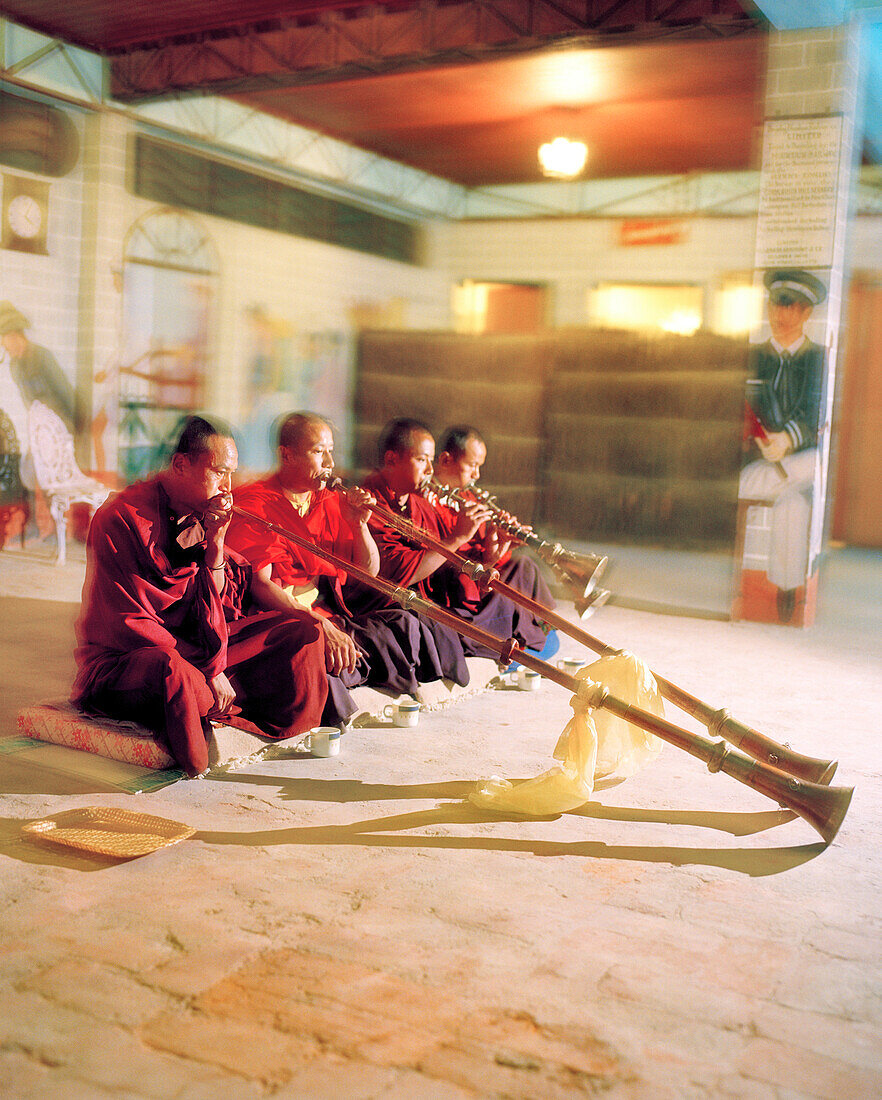 INDIA, West Bengal, monks blowing musical horns, Cochrane Palace, Kurseong