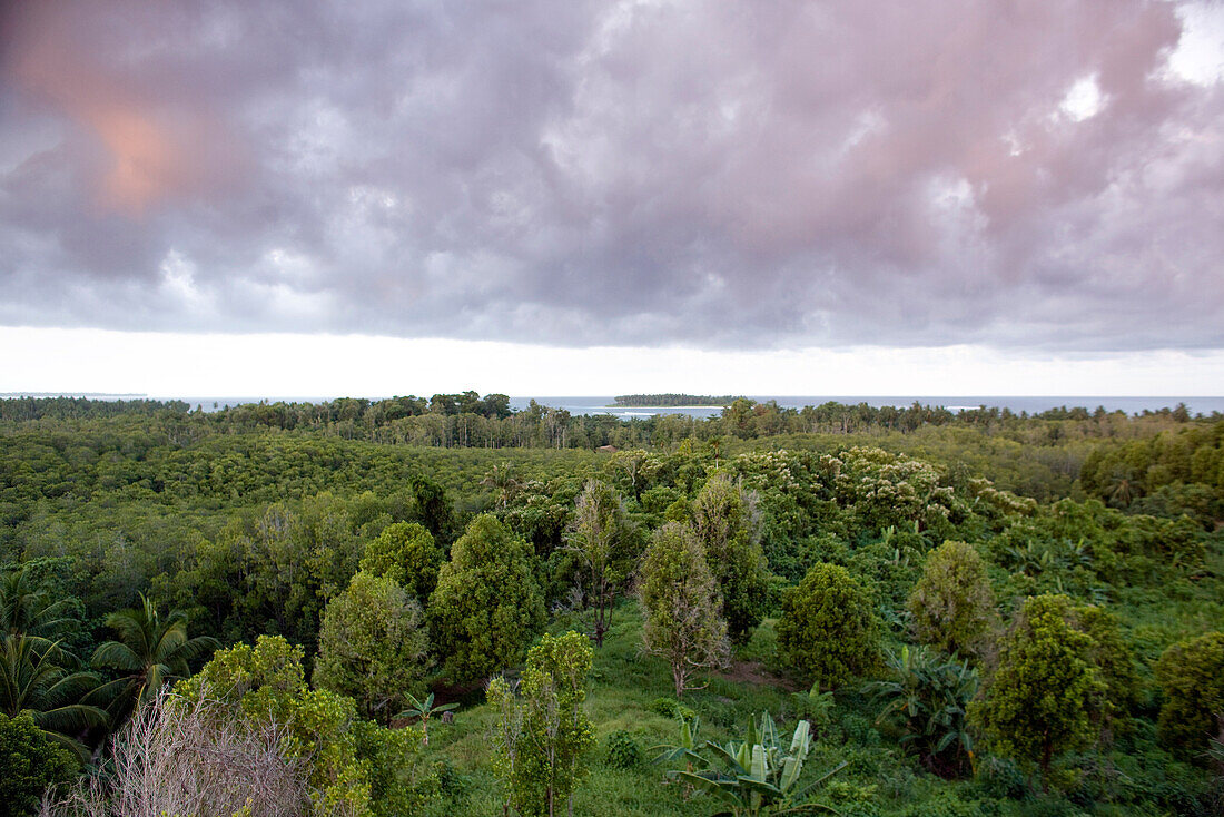 INDONESIA, Mentawai Islands, Kandui Surf Resort, elevated view of Karangmajat Island with the Indian Ocean against a cloudy sky