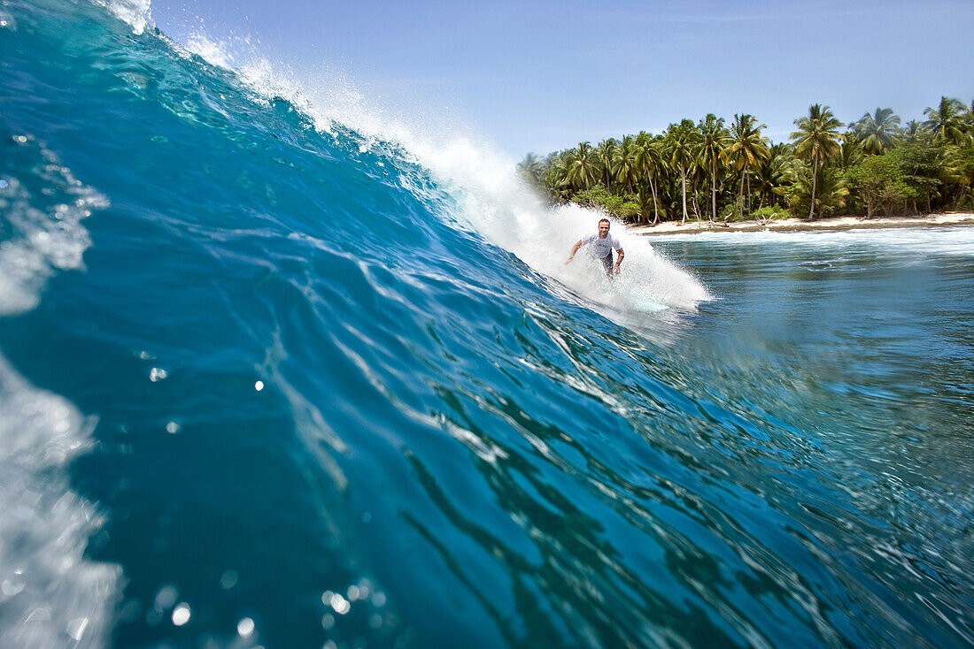 INDONESIA, Mentawai Islands, Kandui Surf Resort, young man surfing on wave, Nupussy