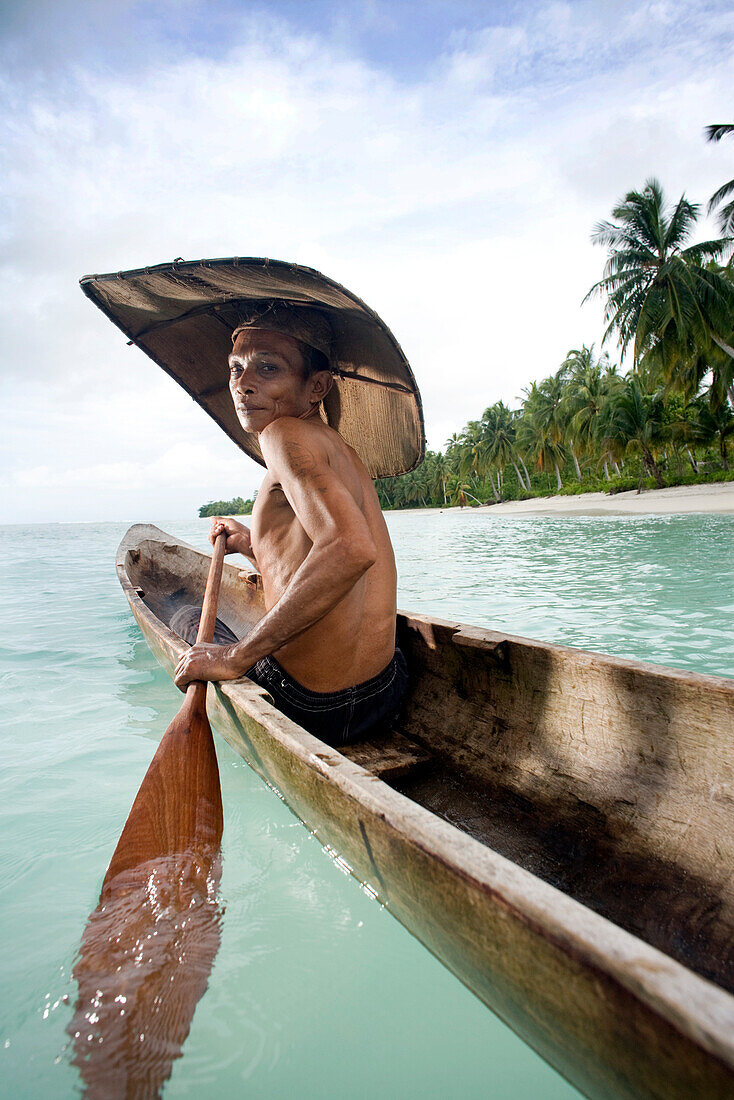 INDONESIA, Mentawai Islands, Kandui Resort, portrait of a Mentawai fisherman, Gesayas Ges, in his dugout canoe