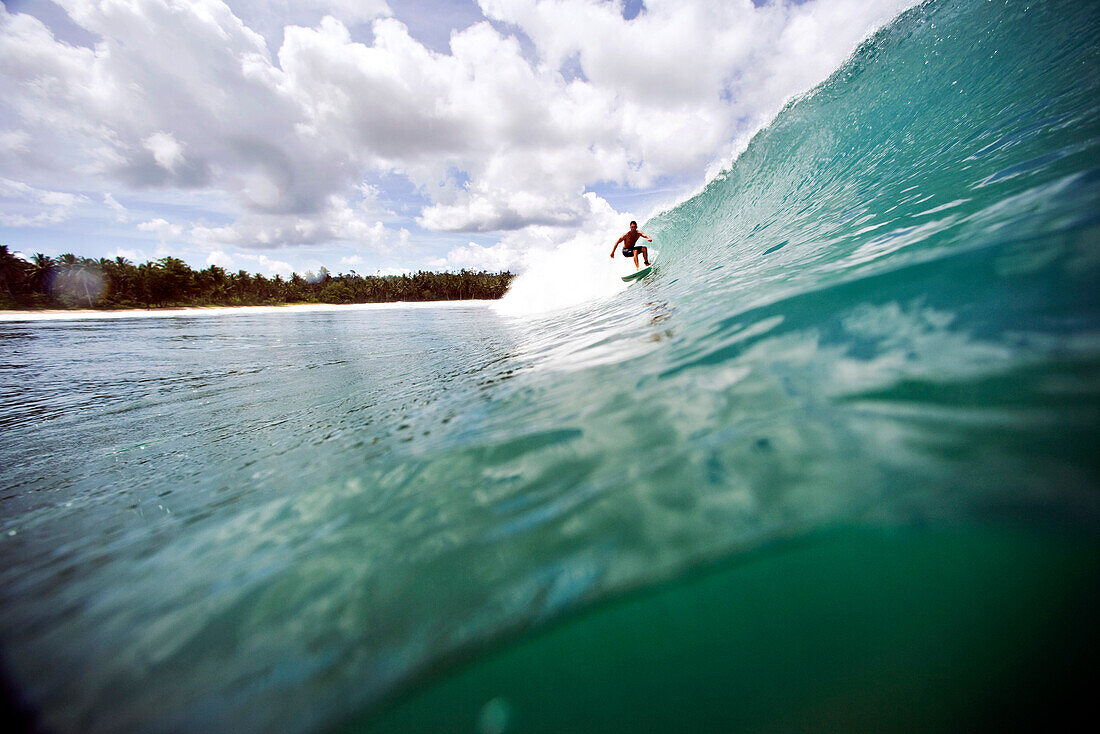 INDONESIA, Mentawai Islands, Kandui Resort, man surfing on a wave at a break called Beng Beng