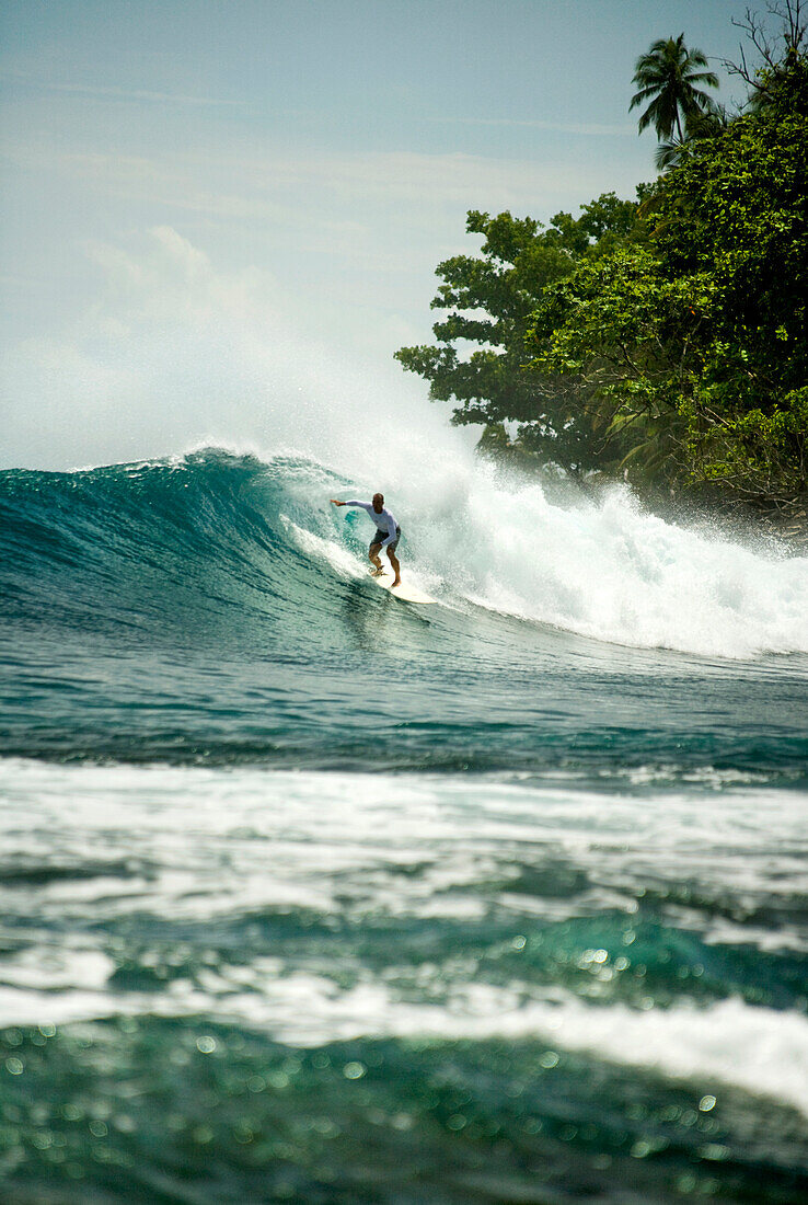 INDONESIA, Mentawai Islands, Kandui Resort, a man surfing a wave, Nipussi