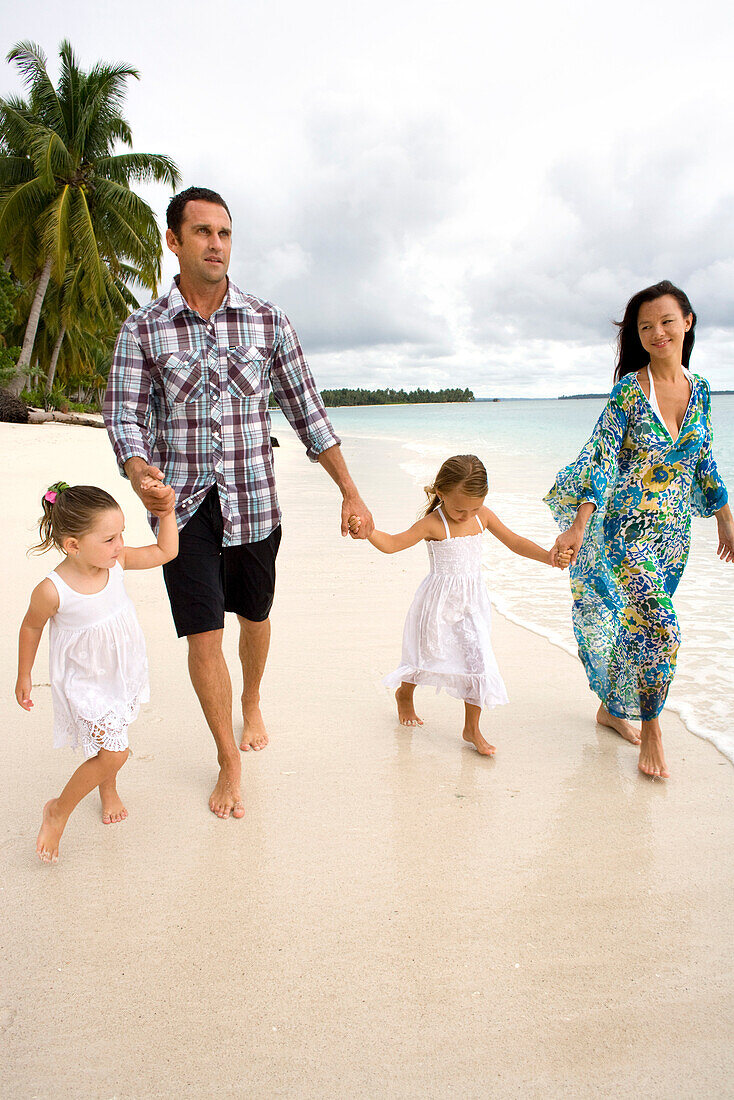 INDONESIA, Mentawai Islands, Kandui Resort, family walking on the beach