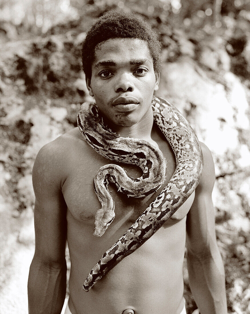 MADAGASCAR, Nosy Komba Island, young man with Boa Constrictor, Agrantopis Village (B&W)