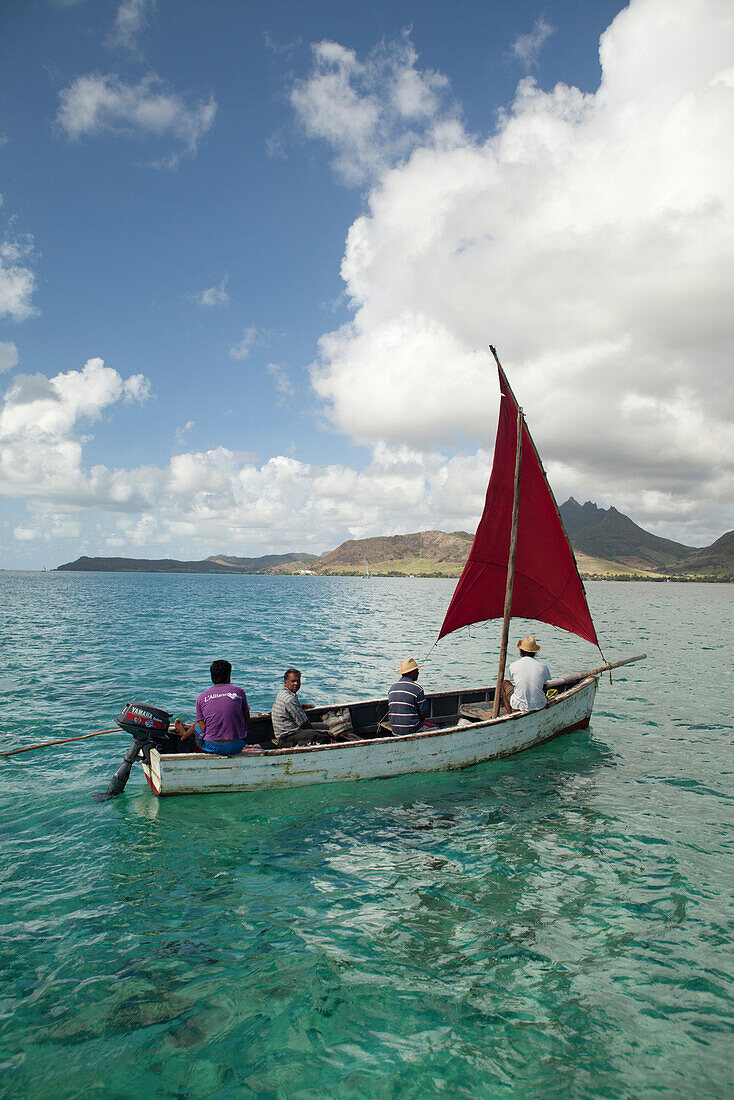 MAURITIUS, Trou D'eau Deuce, sailors on the East coast of Mauritius with the 4 Sisters Mountains in the background, Indian Ocean
