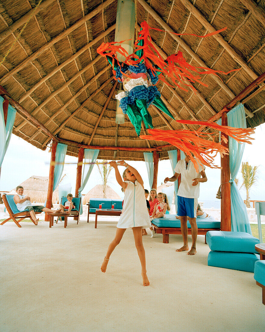 MEXICO, Maya Riviera, girl swinging at a pinyata, Hotel Azul, Yucatan Peninsula
