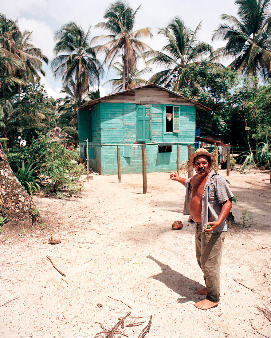 PANAMA, Bocas del Toro, a local man in front of his home by the Caribbean Sea, Central America