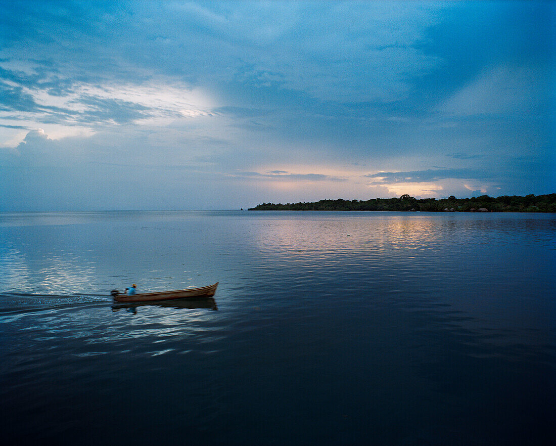 PANAMA, Bocas del Toro, a fisherman drives his boat in the earl morning dawn, Central America