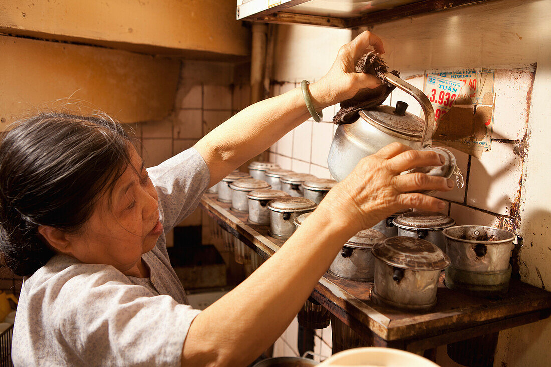 VIETNAM, Hanoi, Miss Tahi owner of Cafe Nang coffee shop prepares coffee for customers in the Old quarter