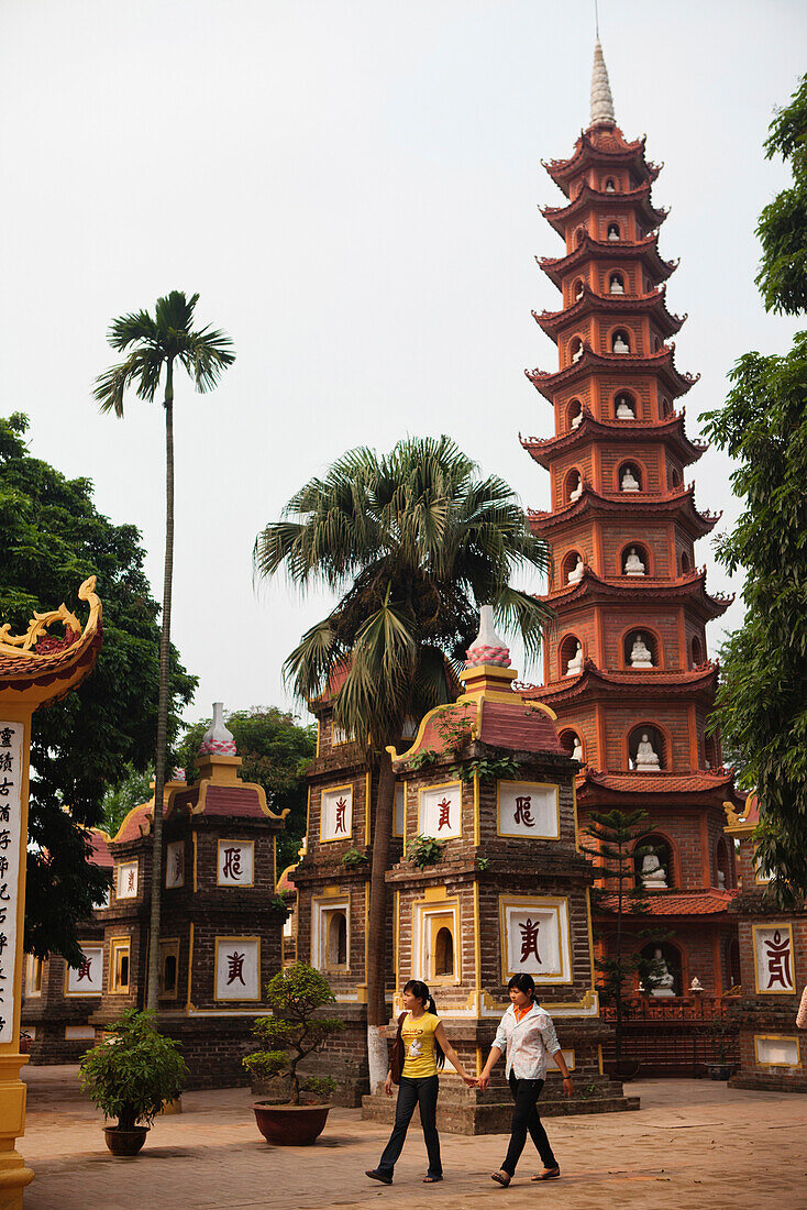 VIETNAM, Hanoi, a young couple walk around the Tran Quoc Pagota located at Hoan Kiem Lake