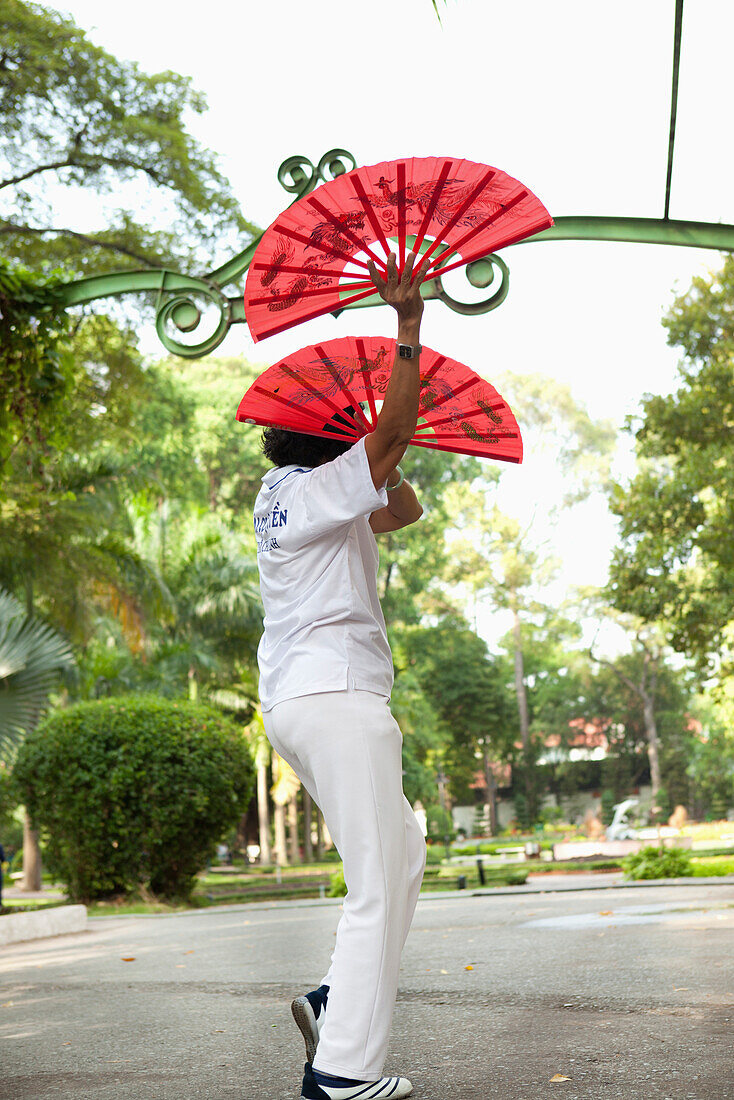 VIETNAM, Saigon, Ho Chi Minh City, woman exercise and perform perfect movements with fans in the early morning