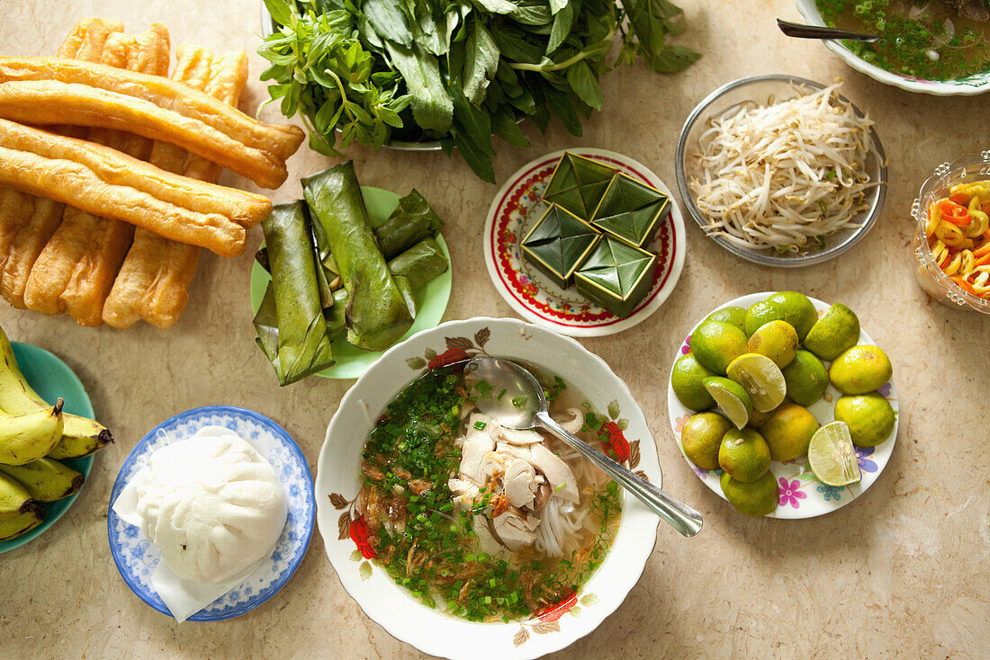 VIETNAM, Saigon, restaurant Pho Hoa aka Pho Hoa Pasteur, a shot of chicken pho in a bowl, dressed with scallions and fresh green herbs atop, and many side dishes, Ho Chi Minh City