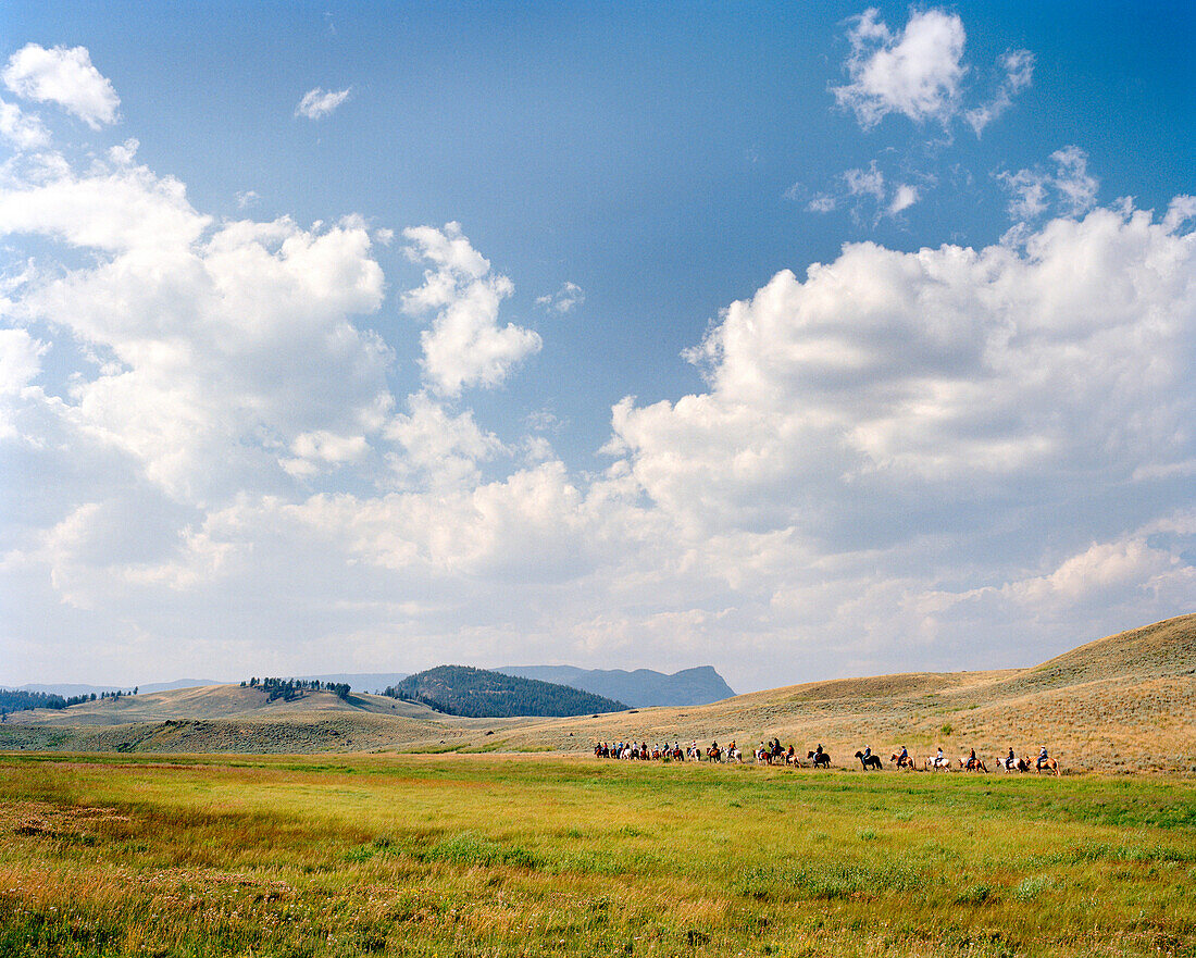 USA, Wyoming, group of people on horseback in vast landscape, Yellowstone National Park