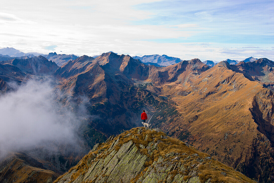 Hicker with dog standing on mount Deneck, Schladminger Tauern, Styria, Austria