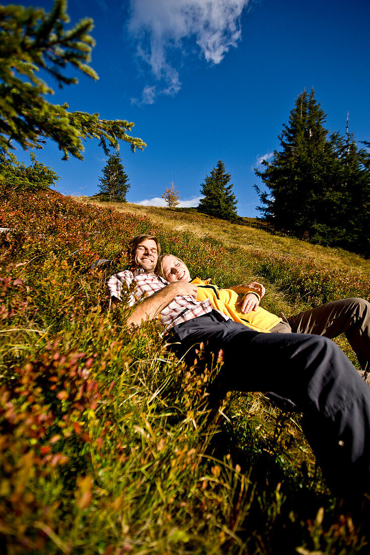 Hikers lying on autumnal alp, Planai, Schladming, Styria, Austria