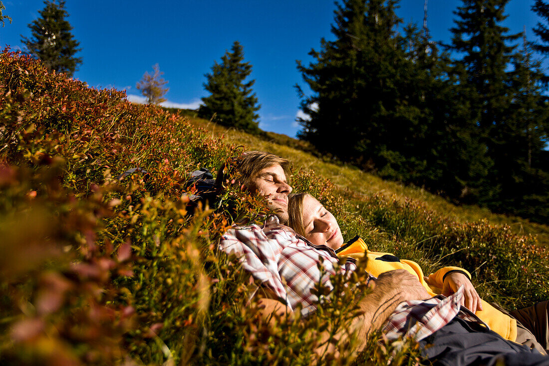 Wanderer liegen auf einer herbstliche Alm, Planai, Schladming, Steiermark, Österreich