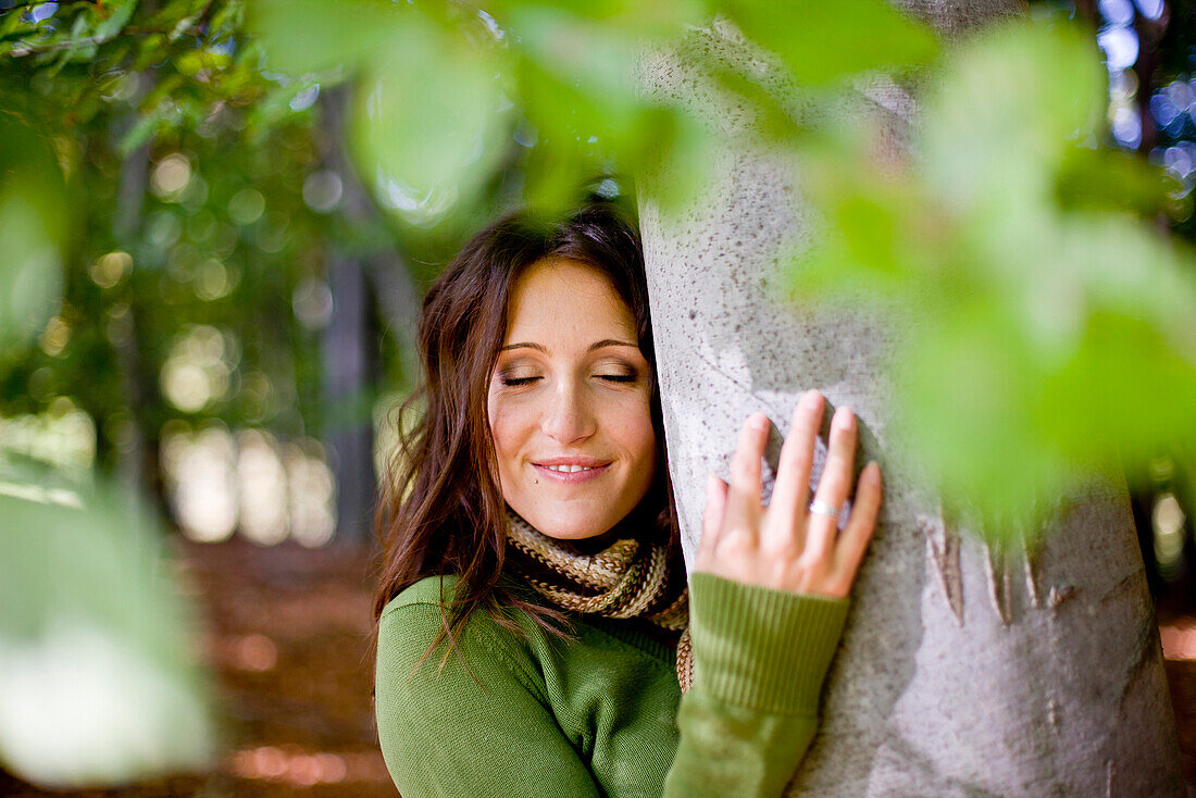 Young woman embracing a tree, Styria, Austria