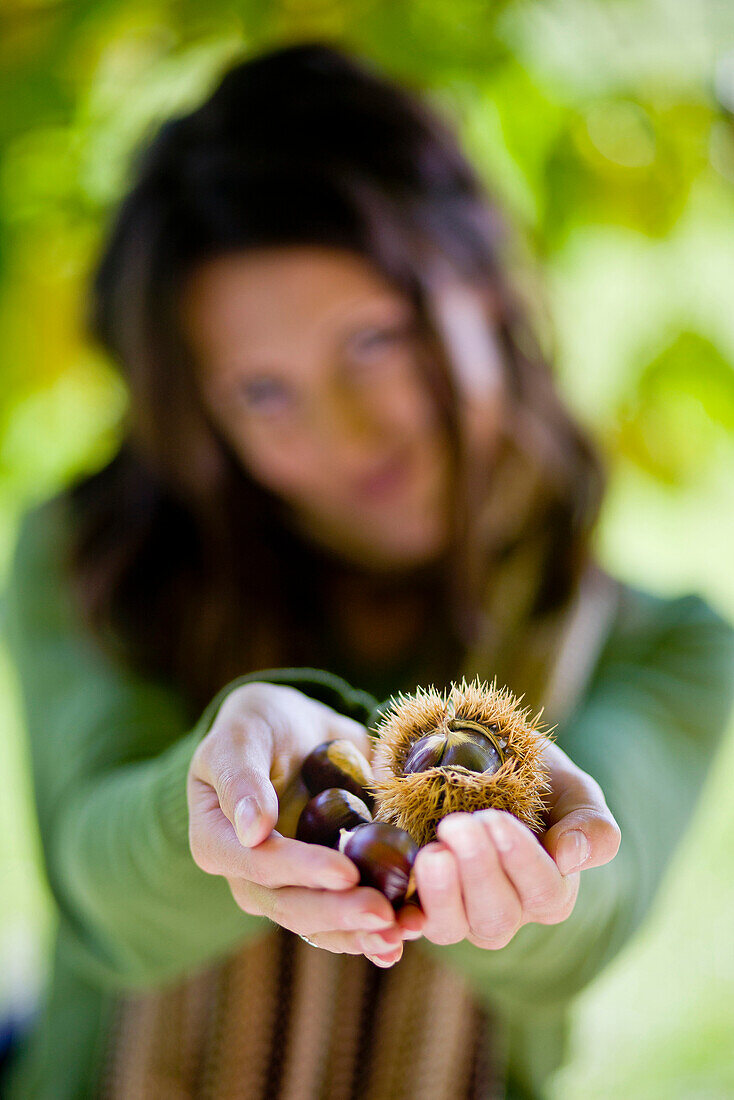 Young woman holding chestnuts in hands, Styria, Austria