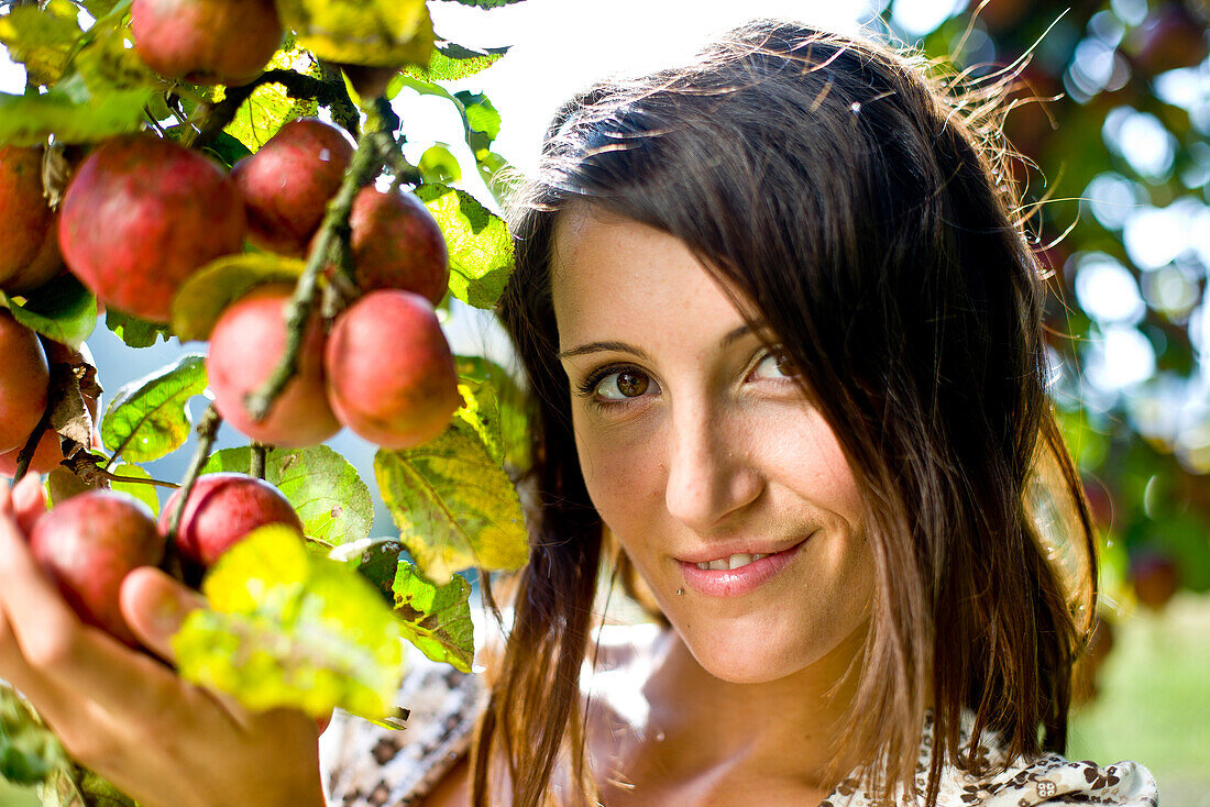 Young woman under an apple tree, Styria, Austria