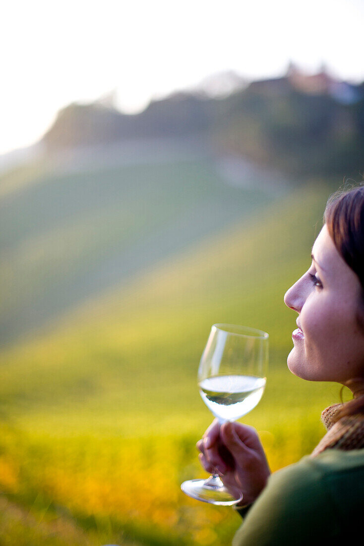 Young woman holding a glass of white wine, Spielfeld, Styria, Austria