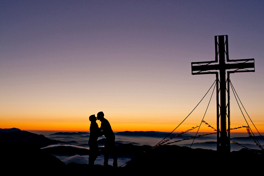 Zwei Wanderer am Hochschwabgipfel bei Sonnenaufgang, Hochschwab, Steiermark, Österreich