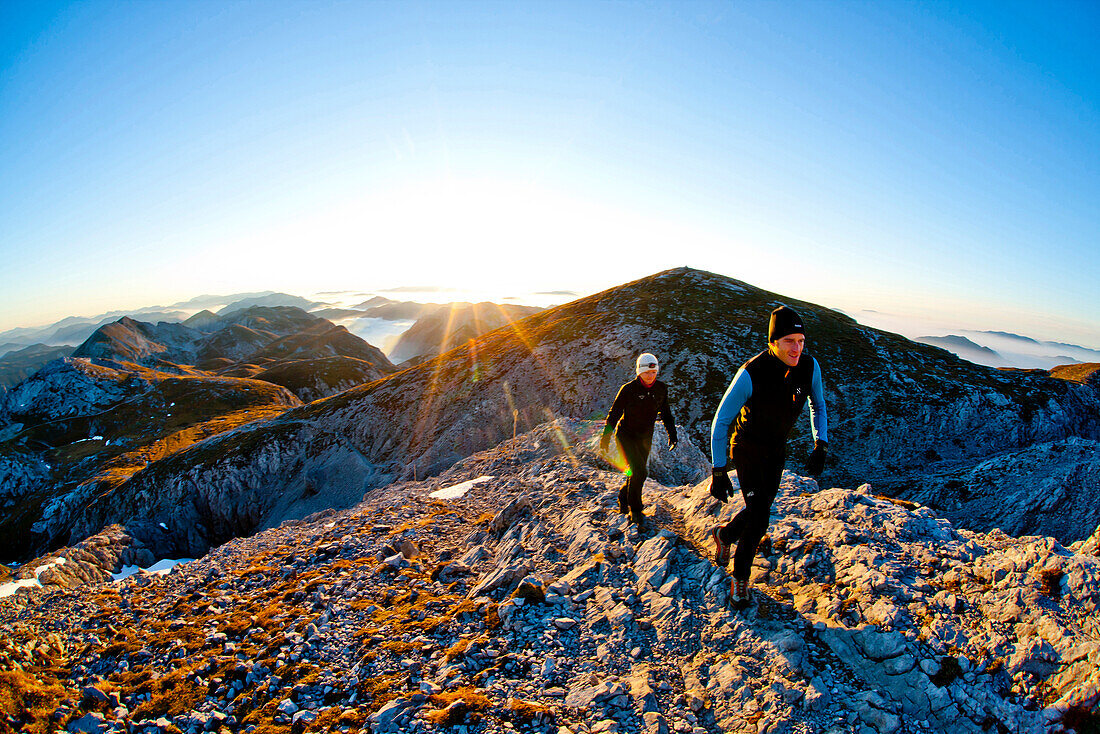 Zwei Wanderer am Hochschwabgipfel bei Sonnenaufgang, Hochschwab, Steiermark, Österreich