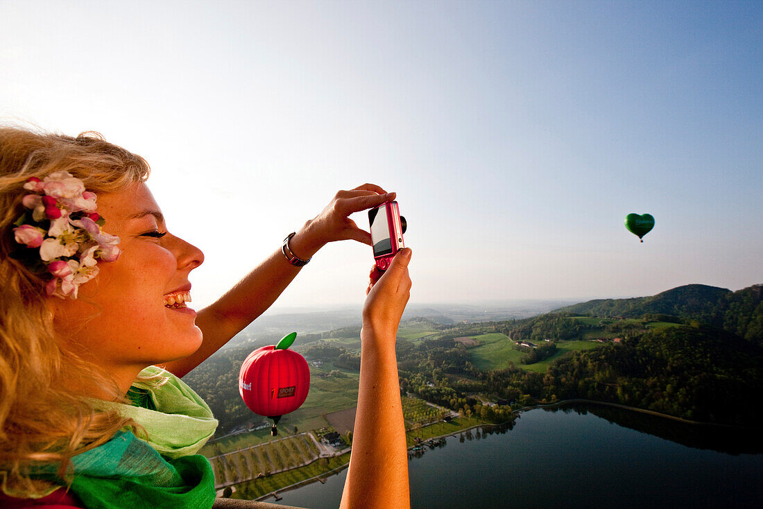 Junge Frau fährt mit einem Heißluftballon, Sulmsee, Steiermark, Österreich