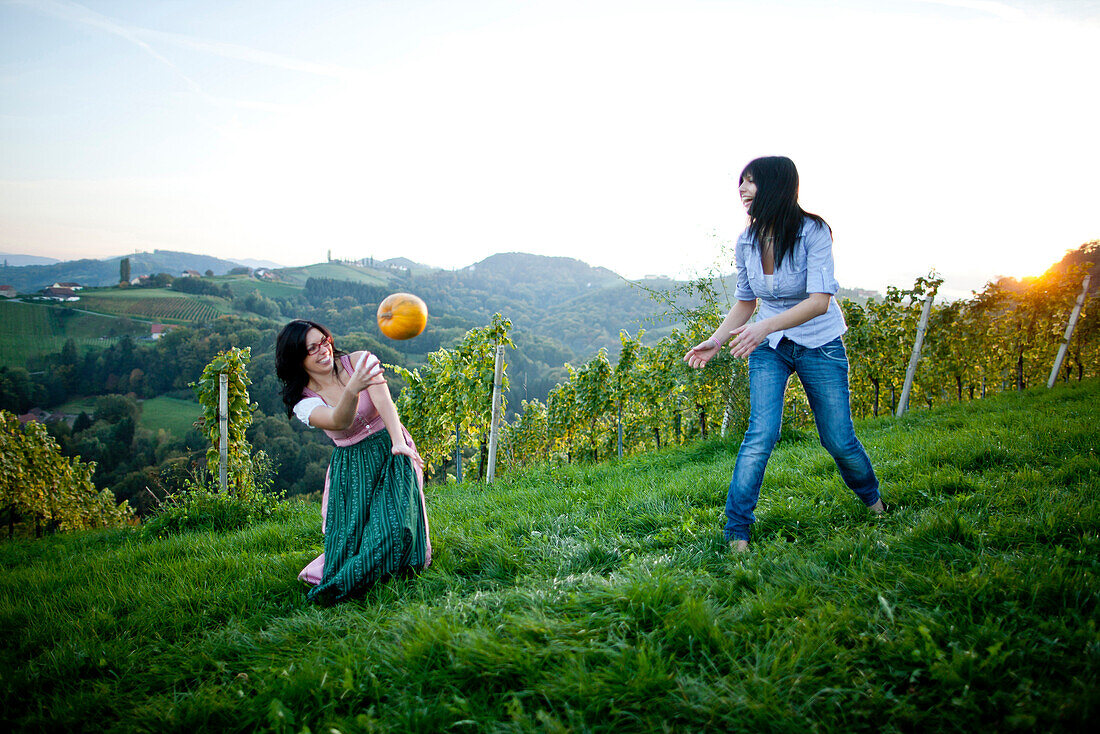 Junge Frauen werfen sich einen Kürbis zu, Steiermark, Österreich