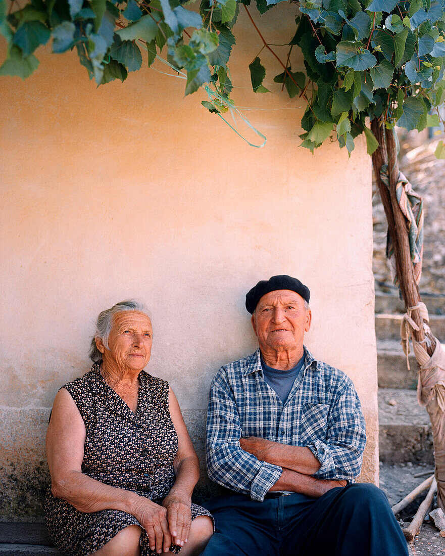 CROATIA, Hvar, Dalmatian Coast, Ivan Tomisic and Vica Tomisic sitting outside house their house in Hvar Island.