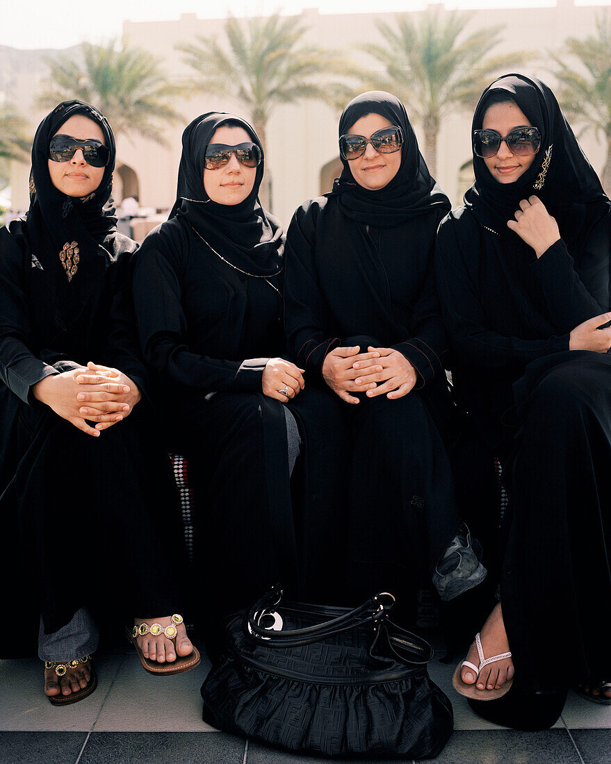 OMAN, Muslim women sitting side by side in traditional clothing at the Barr Al Jissa Resort and Spa