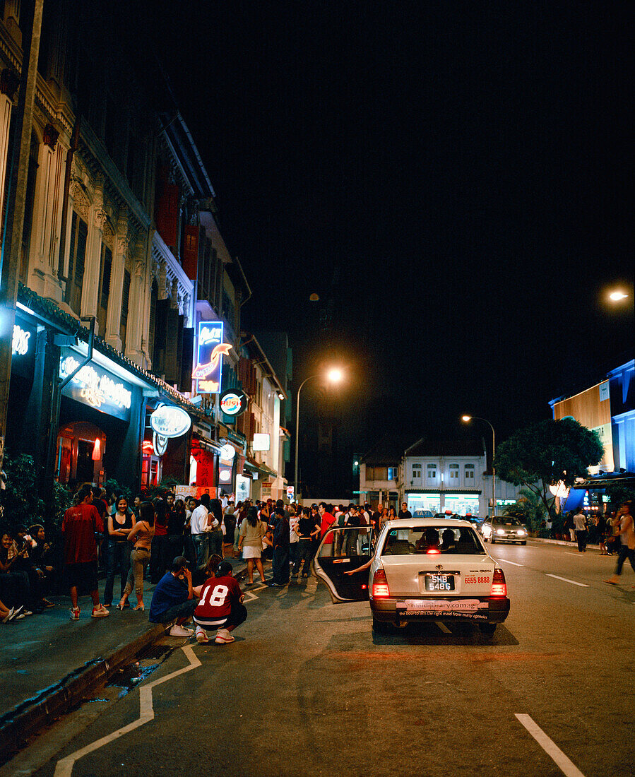 SINGAPORE, Asia, people waiting outside bar at Mohammed Sultan road at night