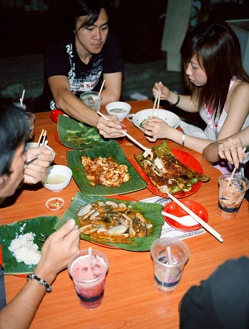 SINGAPORE, Asia, group of people eating dinner at Chinatown restaurant