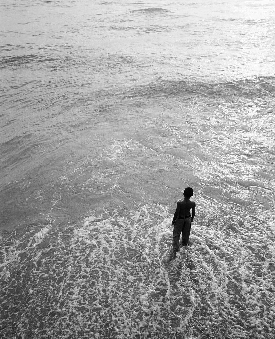 SRI LANKA, Asia, Colombo, high angle view of a boy standing in the Indian Ocean at Colombo (B&W)