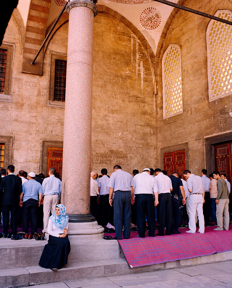 TURKEY, Istanbul, rear view of people praying at Sultan Ahmed mosque