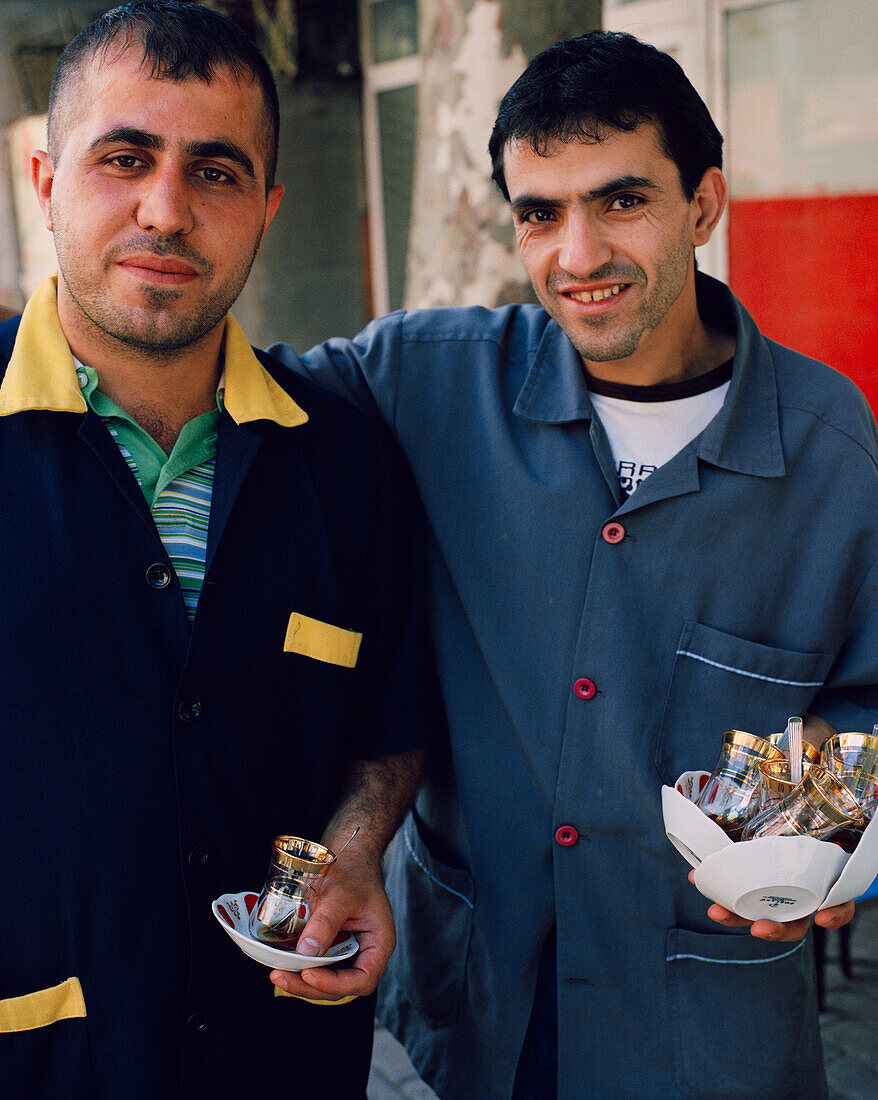 TURKEY, Istanbul, portrait of mid adult men holding tea cups