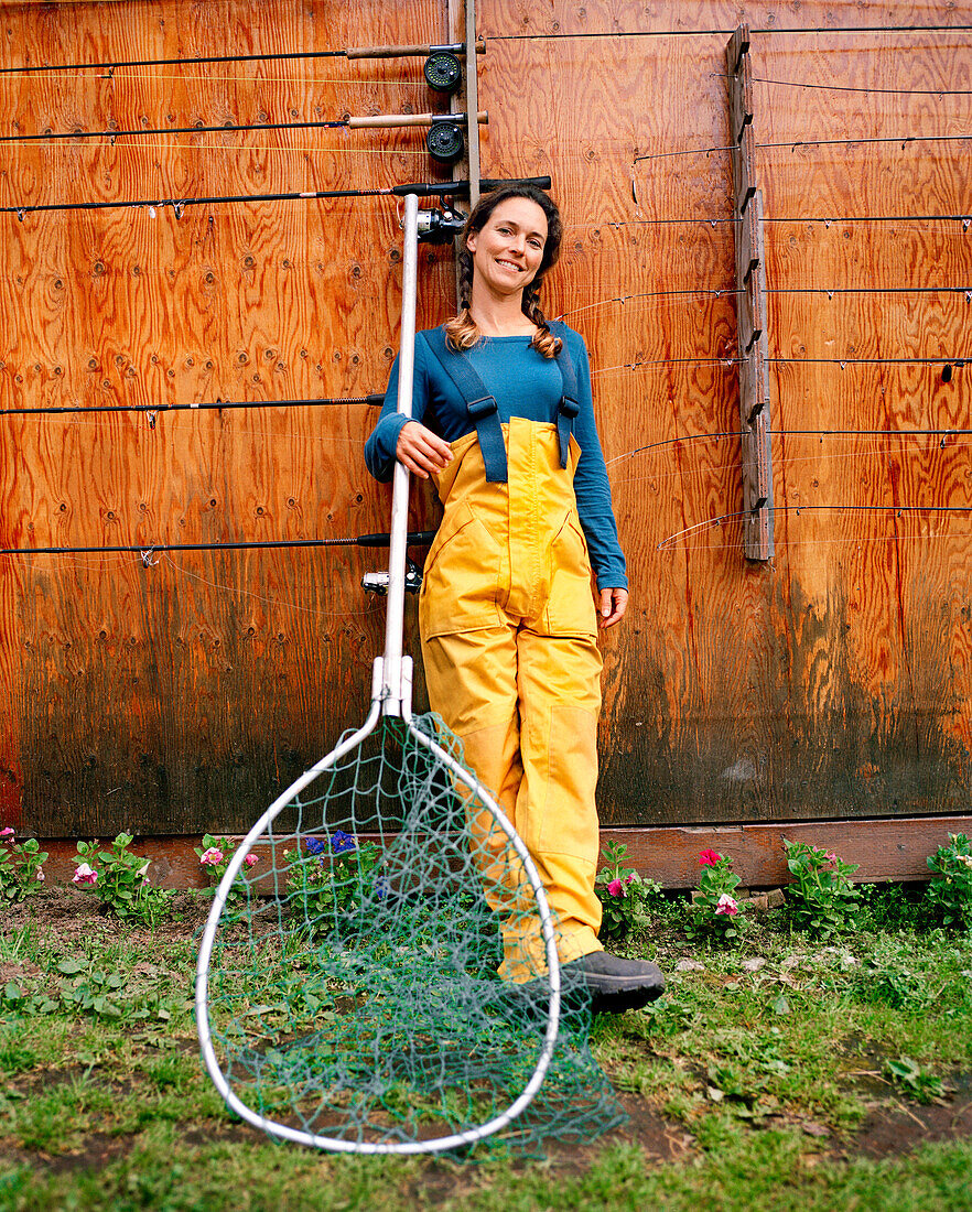 USA, Alaska, young woman holding fishing net, Redoubt Bay Lodge
