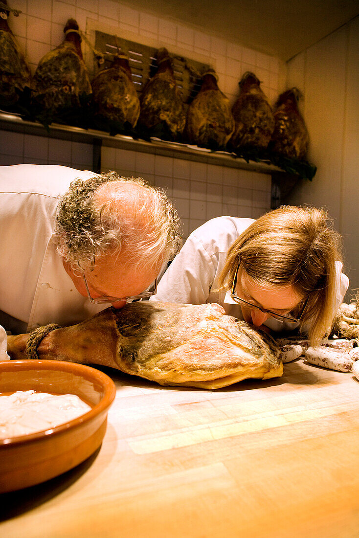 USA, California, chefs smelling cured meat in kitchen, Eccolo Restaurant, Berkeley