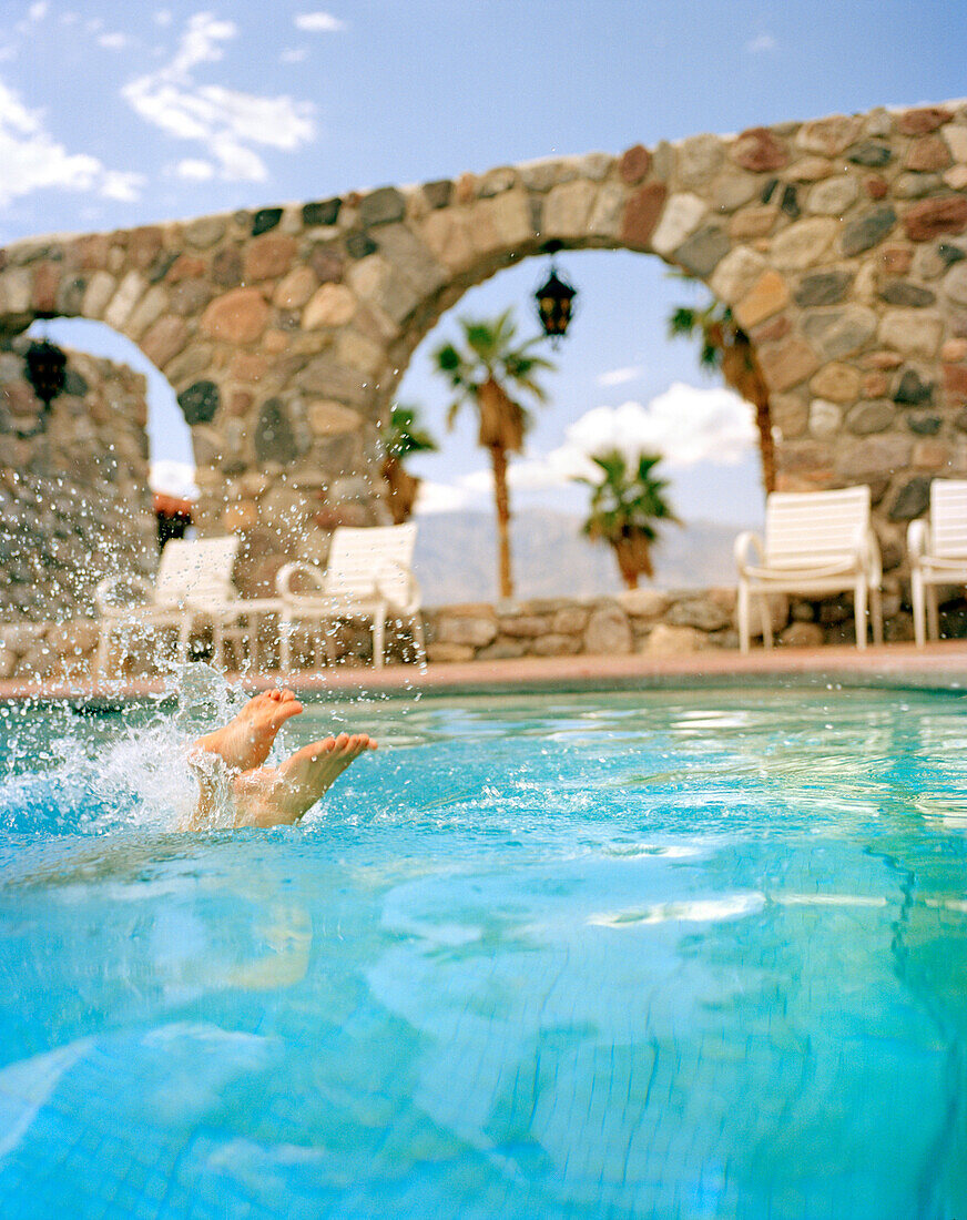 USA, California, Death Valley, woman diving in swimming pool, Furnace Creek Inn