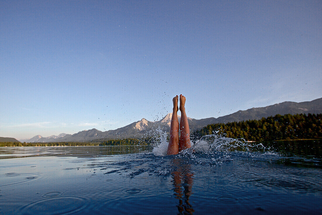 Woman jumping into the Lake Faaker, Alpe-Adria-Trail, Carinthia, Austria