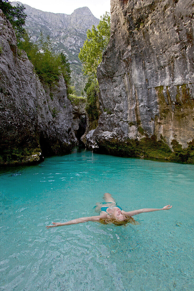 Young woman bathing in the river Soca, Alpe-Adria-Trail, Tolmin, Slovenia