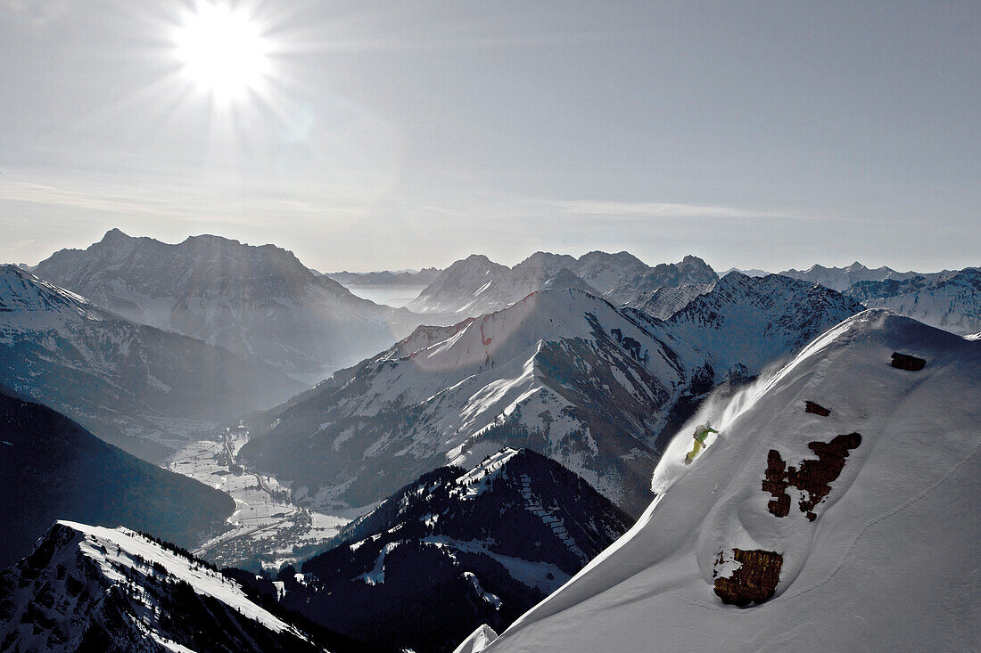 Snowboarder downhill riding in deep snow, Thaneller, Lechtal Alps, Tyrol, Austria