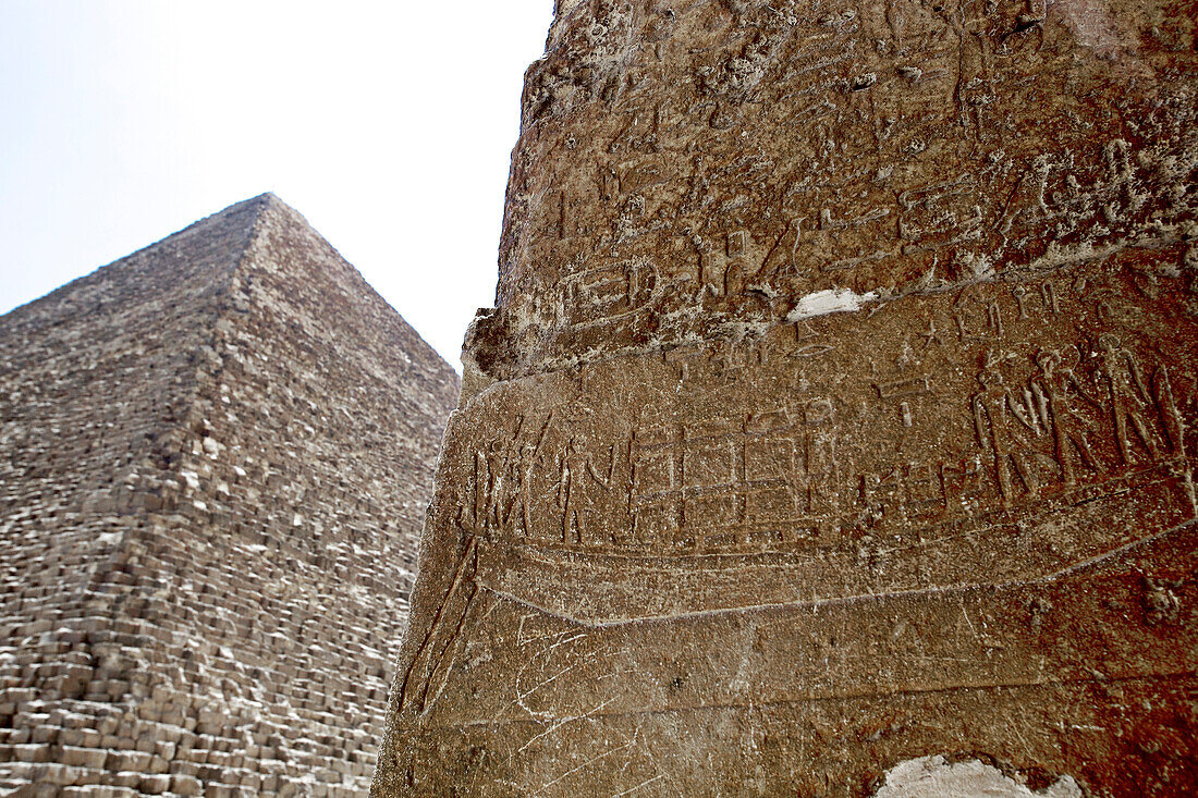 Wall covered with hieroglyphs, pyramid in background, Giza, Giza Governorate, Egypt